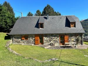 a stone house with a picnic table in front of it at Le Gîte Escalletas in Arrens-Marsous