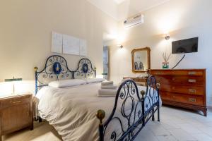 a bedroom with a blue and white bed and a dresser at Lucca Charm in Lucca