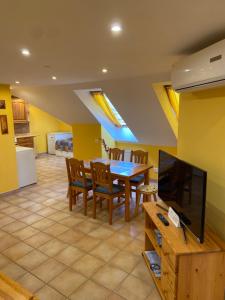 a dining room with a table and a television at Apartment Roman villa in Hévíz
