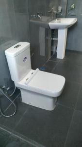a bathroom with a white toilet and a sink at Villa C & C Thalpe in Talpe