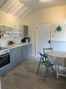 a kitchen with a table and a table and chairs at Chestnut Cottage New Forest in Brockenhurst