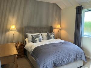 a bedroom with a bed and a desk and a window at Chestnut Cottage New Forest in Brockenhurst