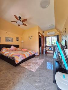 a bedroom with a bed and a ceiling fan at บ้านน้ำผึ้งโฮมสเตย์ Pool & Garden in Suan Phung +122 photos