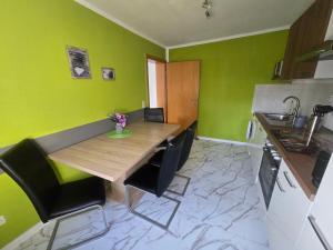 a kitchen with a wooden table and black chairs at Ferienwohnung, Apartment, Monteurwohnung mit Klimaanlage Wettin-Löbejün in Gottgau