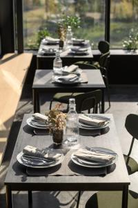 a row of tables with plates and napkins on them at Evergreen Retreat in Râșca