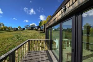 a house with glass doors and a balcony at Evergreen Retreat in Râșca