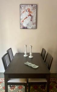 a dining room table with chairs and a painting on the wall at Parva Domus Intera casa indipendente in centro in Modica +14 photos