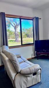 a living room with a couch and a large window at StudioONE in Whitemark