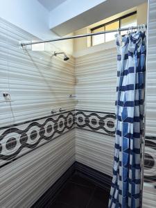 a shower with a blue and white shower curtain at Apart La Merced in Caraz +117 photos