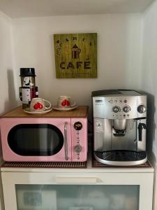 a pink microwave and a coffee maker on a counter at Stadtvilla Jelena Mengen in Mengen