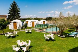 a group of tents with tables and chairs in the grass at Igloo Rooms - Belorado in Belorado