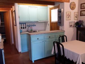 a kitchen with blue cabinets and a sink and a table at Villa Silvia in Costa Rei