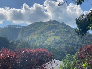 a mountain with a temple on top of it at Happiness Cottage in Ella