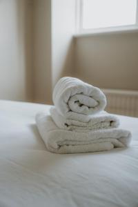 a stack of towels sitting on top of a bed at Florence House Bed & Breakfast in Seaford +79 photos