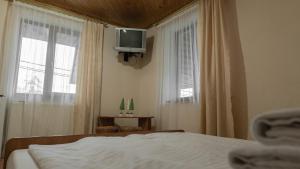a bedroom with a bed and a tv on the wall at Готель Меридіан in Yasinya