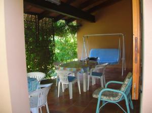 a porch with a table and chairs and a cat on it at Villa Silvia in Costa Rei