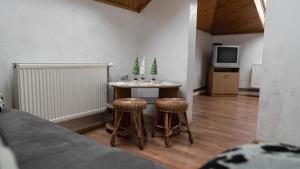 a room with a table and two stools and a tv at Готель Меридіан in Yasinya