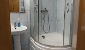 a shower with a glass door next to a sink at Готель Меридіан in Yasinya