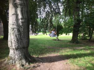a woman sitting on a swing in a park at Schlaffass in Neumark +2 photos