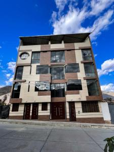 a building with a clock on the side of it at Apart La Merced in Caraz