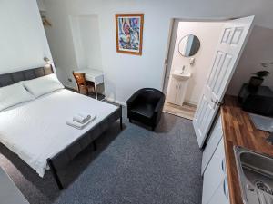 a small bedroom with a bed and a sink at Rose Studio - Self Contained Studio Flat in Oxford