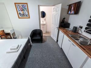 a small kitchen with a sink and a chair at Rose Studio - Self Contained Studio Flat in Oxford +11 photos