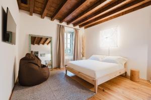 a bedroom with a white bed and a large window at Locanda Scotti in Paladina