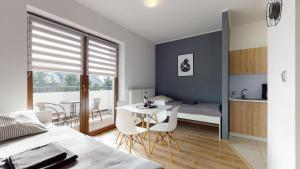 a bedroom with a bed and a table and chairs at Apartament Fibra Crema in Rybnik
