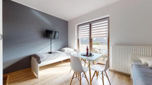 a bedroom with a bed and a table and chairs at Apartament Fibra Crema in Rybnik