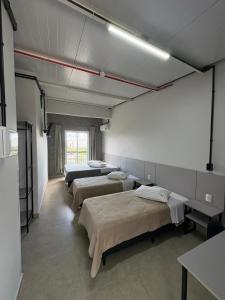 a row of beds in a room with a row at Sierra Lages Hotel in Lages