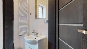 a white bathroom with a sink and a mirror at Apartament Fibra Crema in Rybnik +35 photos