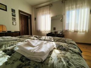 a bedroom with two towels sitting on a bed at Ciasa Cadorina - Relax nelle Dolomiti in Pelos