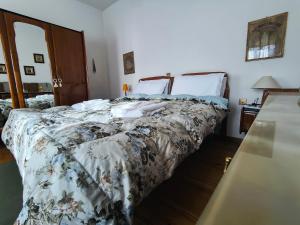 a bedroom with a large bed with a floral bedspread at Ciasa Cadorina - Relax nelle Dolomiti in Pelos
