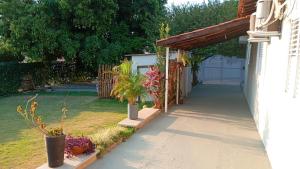 a driveway leading to a garage with potted plants at Recanto Manga da Rosa - casinha de fazenda no centro da cidade in Olímpia