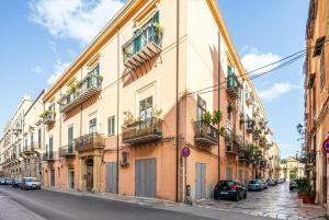 a building with cars parked on the side of a street at Le Stanze al Genio di Darlon in Palermo