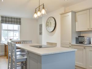 a kitchen with a large clock on the wall at Fern House in Hinderwell