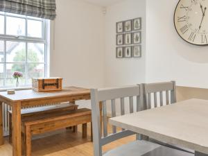 a dining room with a table and a clock on the wall at Fern House in Hinderwell +16 photos