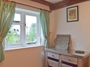 a room with a window and a dresser with a dresser at Three Ash Cottage in Bungay