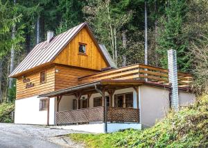 a house with a wooden roof on top of it at Chata Malino in Ružomberok
