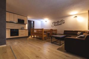 a living room with a couch and a table and a kitchen at Chata Malino in Ružomberok