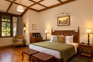 a bedroom with a bed and a chair at The Hill Club - Nuwara Eliya in Nuwara Eliya