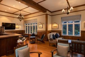 a large living room with chairs and a television at The Hill Club - Nuwara Eliya in Nuwara Eliya