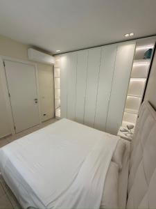 a large white bed in a room with white cabinets at Valamar Residence Apartment with balcony in Draç