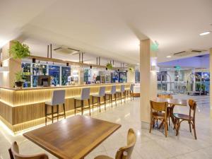 a restaurant with a bar with wooden tables and chairs at Mercure Rio de Janeiro Barra da Tijuca in Rio de Janeiro