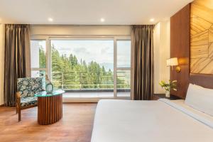 a hotel room with a bed and a large window at Country Inn Premier Pacific Mall Road Mussoorie in Mussoorie +88 photos
