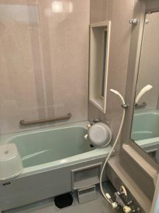 a bathroom with a green tub and a sink at 匠と昊 Naru Sora in Kaga