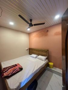 a bed in a room with a ceiling fan at Hotel Chilika in Bālugān