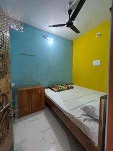 a bed in a room with yellow and blue walls at Hotel Chilika in Bālugān