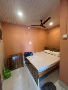 a bed in a room with a ceiling at Hotel Chilika in Bālugān