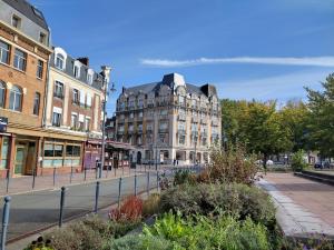 a large building on a street in a city at Hotel Moderne in Arras